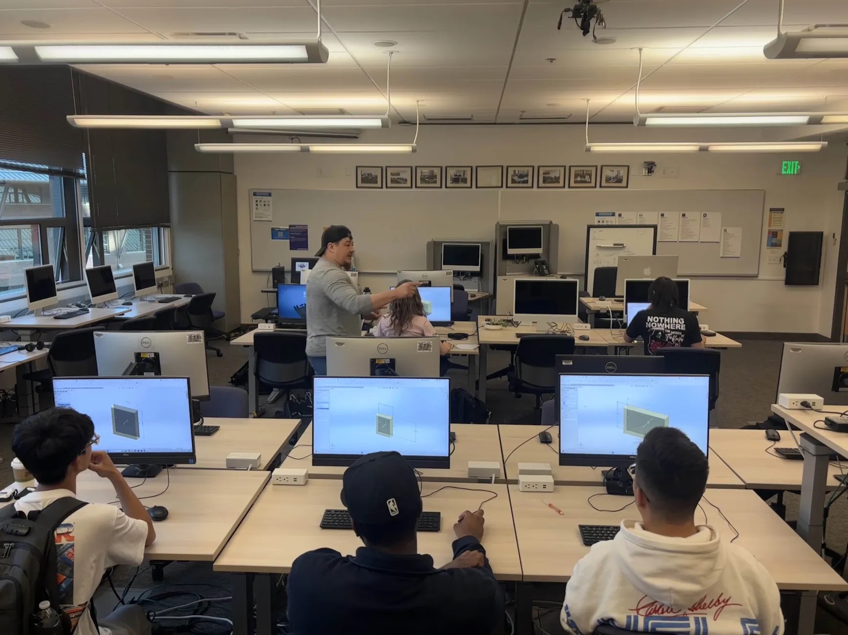 Students sitting at computers collaborating on a CAD design.