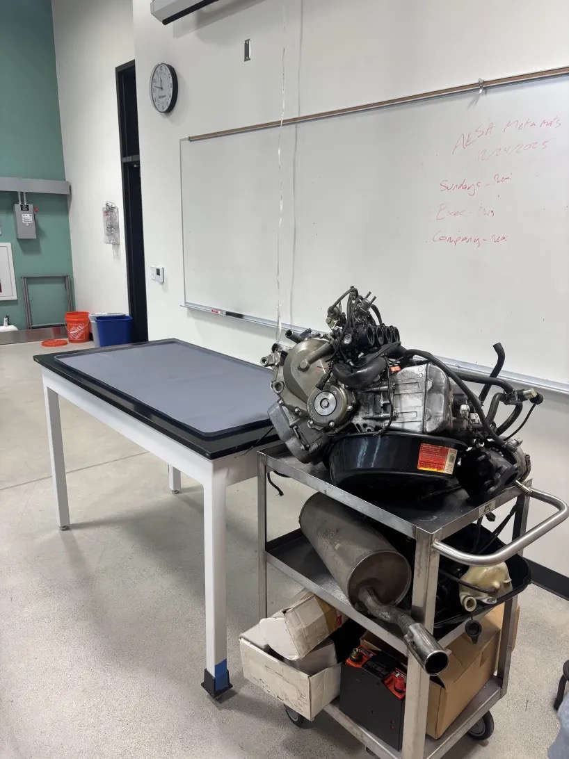 An engine sitting on a table with parts.