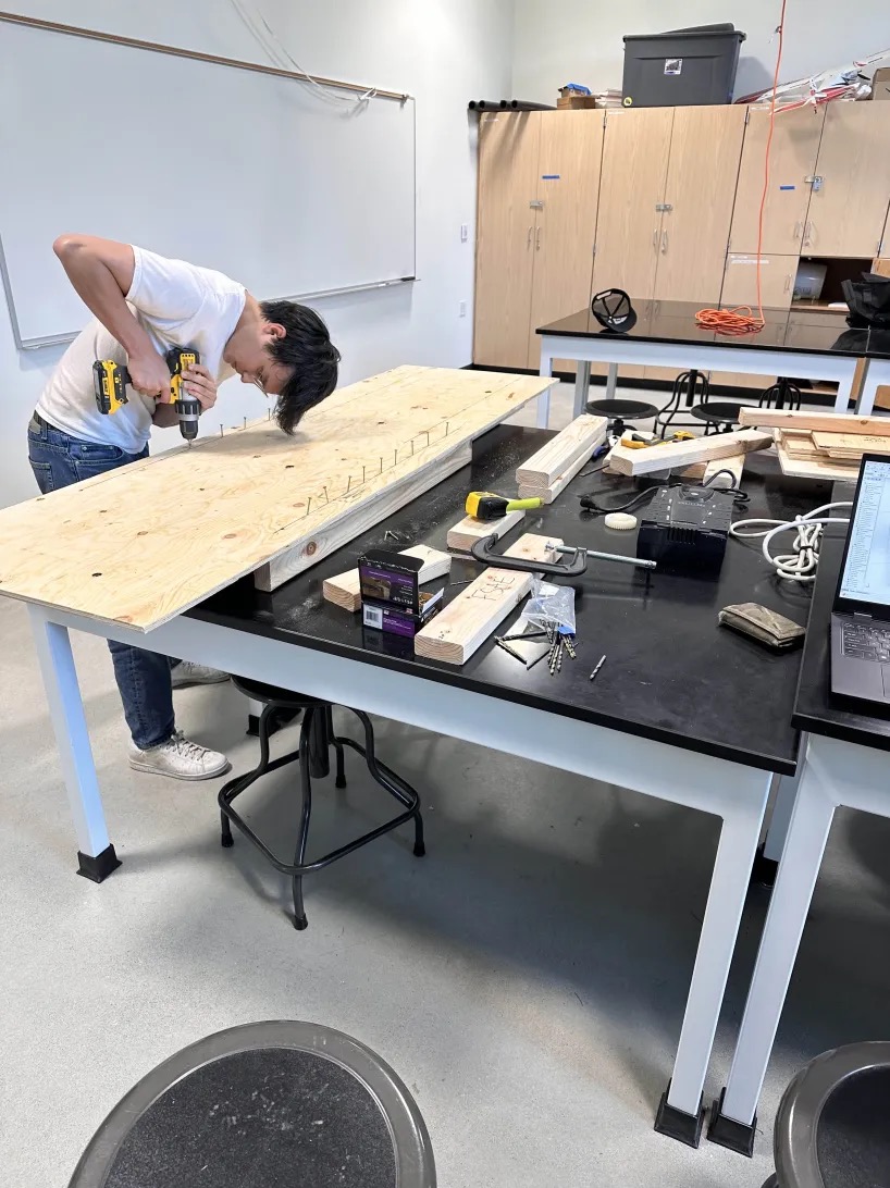 A person drilling on a table.